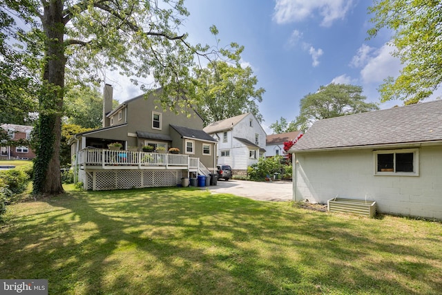 back of house featuring a wooden deck and a lawn