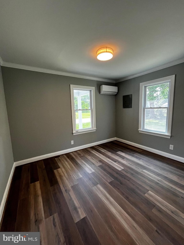 empty room with a wall unit AC, dark wood-type flooring, and ornamental molding