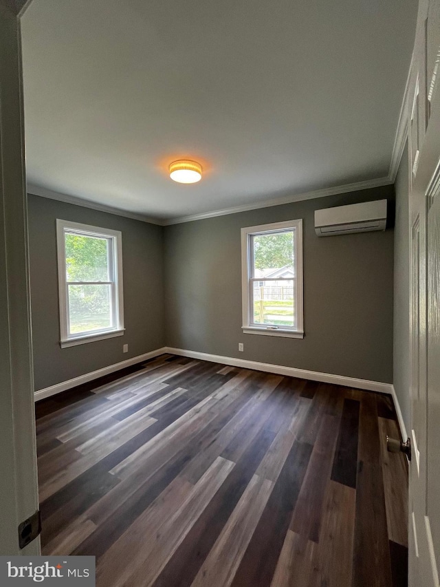 empty room with a wall unit AC, dark wood-type flooring, and crown molding