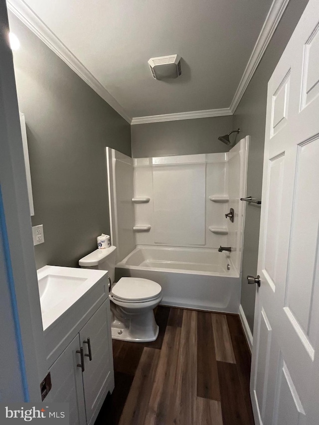 full bathroom featuring toilet, vanity, hardwood / wood-style floors, ornamental molding, and bathing tub / shower combination