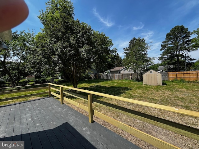 wooden deck featuring a lawn and a storage unit