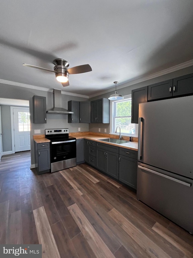 kitchen with appliances with stainless steel finishes, gray cabinetry, hanging light fixtures, wall chimney range hood, and sink