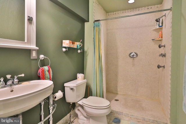 bathroom featuring a shower with curtain, toilet, tile patterned floors, and sink