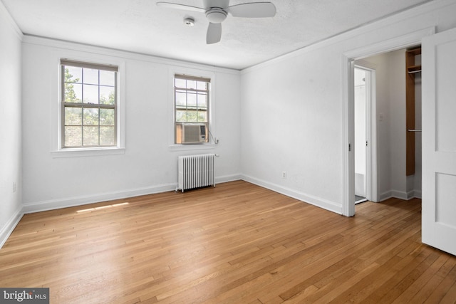 unfurnished room with ceiling fan, radiator heating unit, light hardwood / wood-style floors, a textured ceiling, and ornamental molding