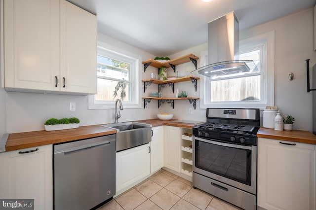 kitchen featuring wooden counters, white cabinets, sink, appliances with stainless steel finishes, and island exhaust hood