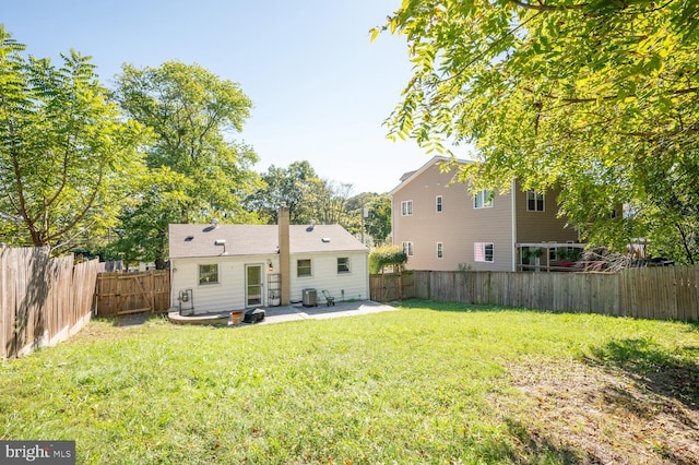 back of house featuring central air condition unit, a yard, and a patio