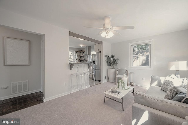 carpeted living room with ceiling fan