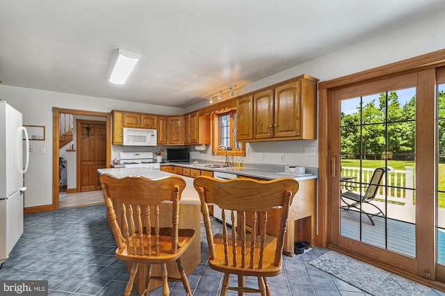 kitchen with sink, a kitchen breakfast bar, tile patterned flooring, kitchen peninsula, and white appliances