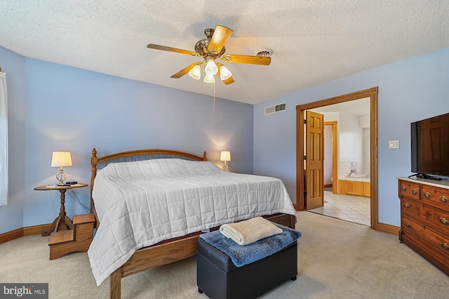 carpeted bedroom with ceiling fan, ensuite bathroom, and a textured ceiling