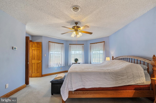 bedroom featuring light carpet, a textured ceiling, and ceiling fan