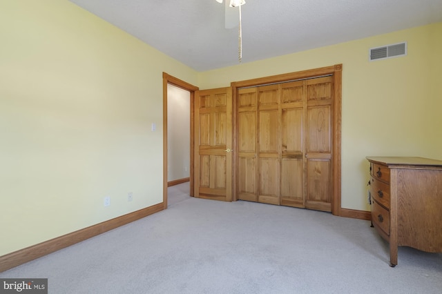 bedroom featuring ceiling fan, light colored carpet, and a closet