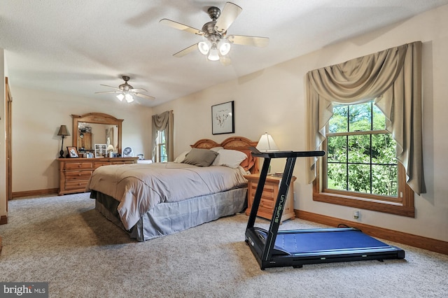 bedroom featuring ceiling fan, carpet floors, and a textured ceiling