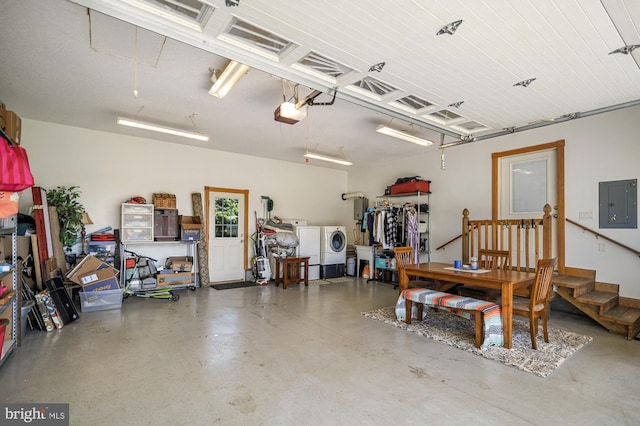 garage with washer and dryer, a garage door opener, and electric panel