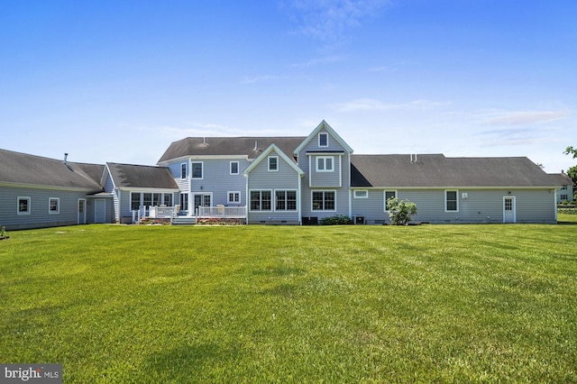 rear view of property featuring a lawn