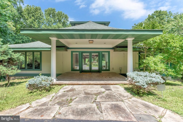 property entrance featuring french doors and roof with shingles