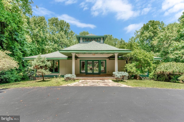 view of front of home featuring a shingled roof, french doors, driveway, and stucco siding