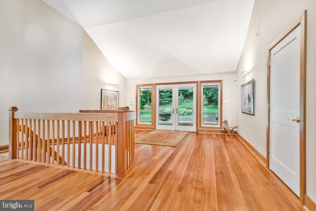 interior space with vaulted ceiling, wood finished floors, and french doors