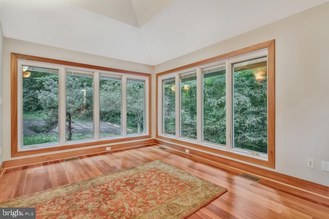 unfurnished sunroom featuring visible vents and vaulted ceiling