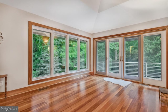 interior space featuring vaulted ceiling, wood finished floors, visible vents, and a wealth of natural light