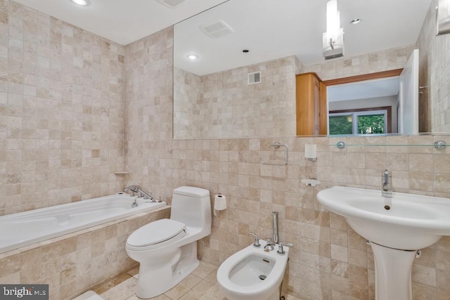 bathroom with tile walls, a relaxing tiled tub, a bidet, and visible vents