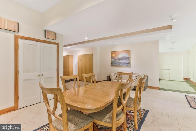 dining space with light tile patterned floors and baseboards