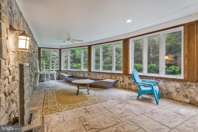 unfurnished sunroom featuring ceiling fan