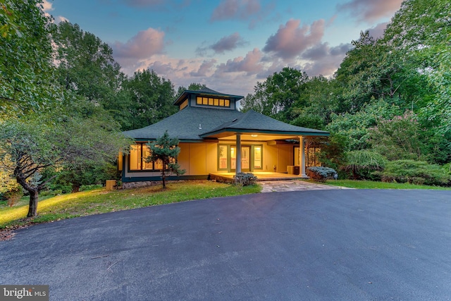 view of front of house with aphalt driveway and roof with shingles