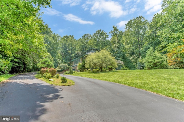 view of street featuring aphalt driveway and a view of trees