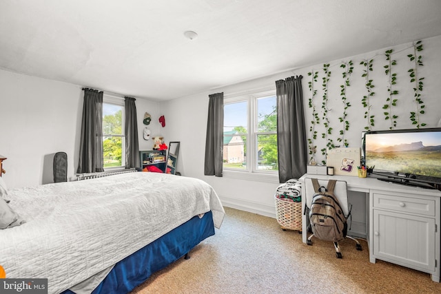 bedroom featuring light carpet and multiple windows