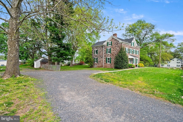 view of front of home featuring an outbuilding and a front lawn