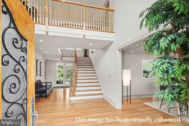 entrance foyer with a towering ceiling and hardwood / wood-style flooring