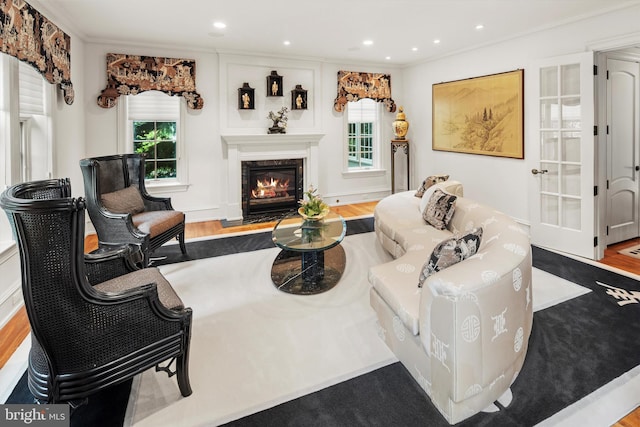 living room featuring light hardwood / wood-style floors, crown molding, and a premium fireplace