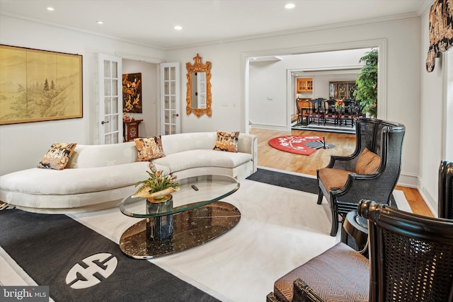 living room featuring french doors, light hardwood / wood-style flooring, and ornamental molding