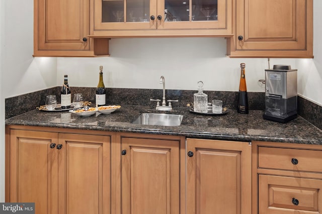 kitchen featuring sink and dark stone counters