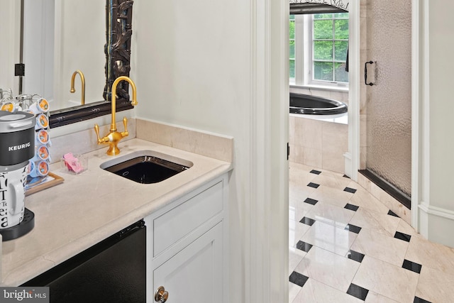 bathroom featuring tiled bath, tile patterned flooring, and vanity