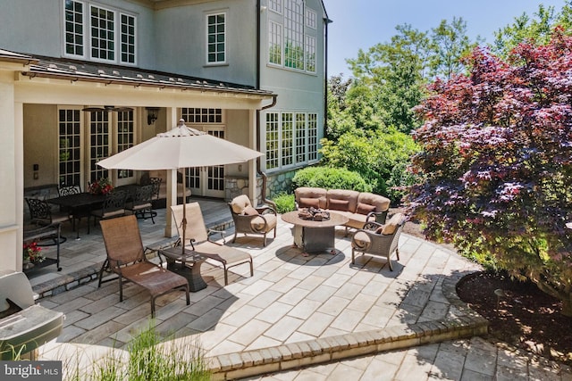 view of patio with french doors and an outdoor living space with a fire pit