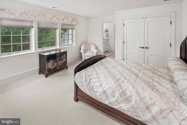 carpeted bedroom featuring connected bathroom and a closet