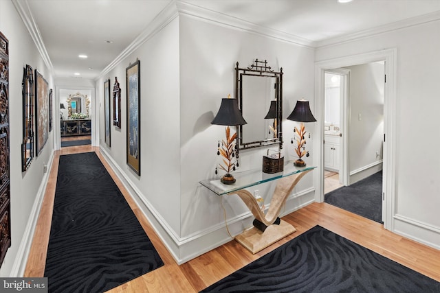 hall with hardwood / wood-style flooring and ornamental molding