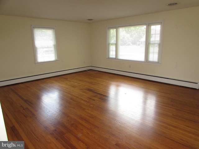 spare room with plenty of natural light and hardwood / wood-style flooring