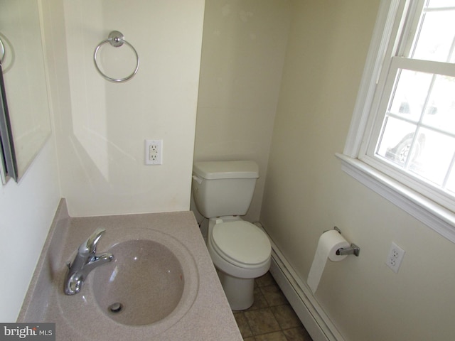 bathroom featuring tile patterned flooring, toilet, sink, and a baseboard radiator