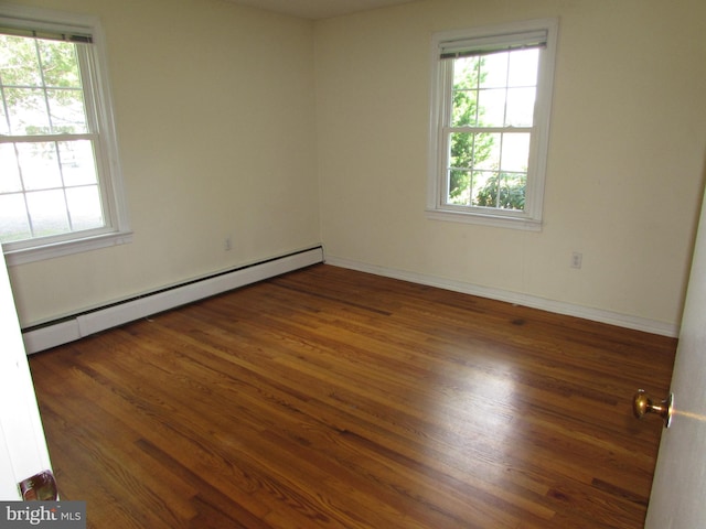 empty room featuring a baseboard radiator and dark hardwood / wood-style floors