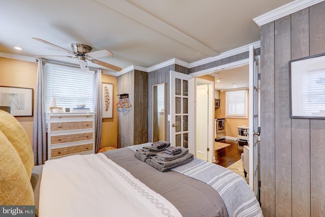 bedroom featuring hardwood / wood-style flooring, ceiling fan, crown molding, and wood walls