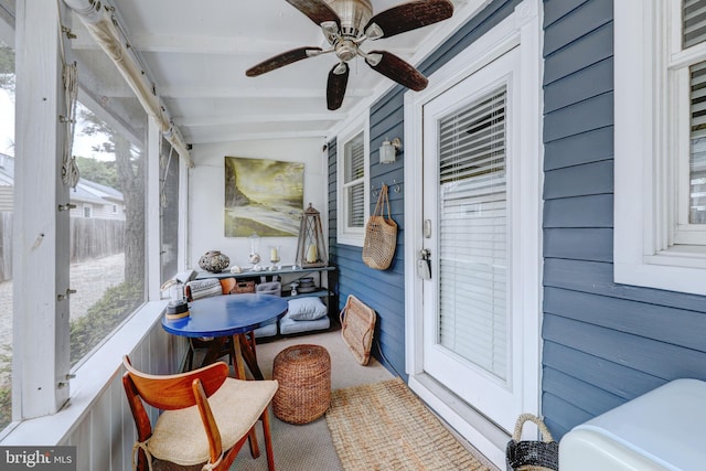 sunroom / solarium featuring ceiling fan and lofted ceiling with beams