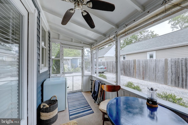 sunroom / solarium featuring lofted ceiling with beams and ceiling fan