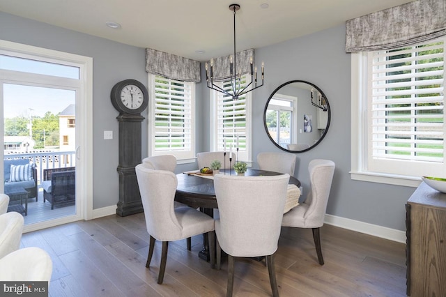 dining space with hardwood / wood-style floors and a chandelier