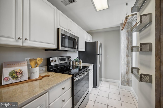 kitchen with white cabinetry, light tile patterned floors, and appliances with stainless steel finishes