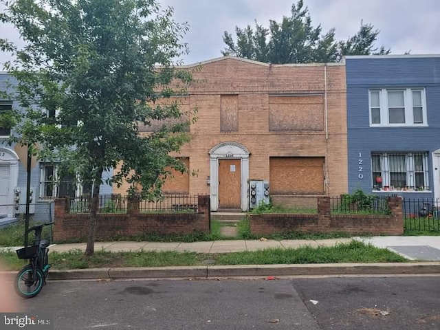 view of property with a fenced front yard and brick siding