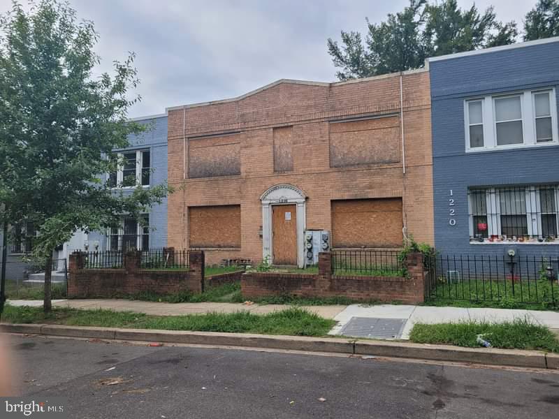 multi unit property with a fenced front yard and brick siding