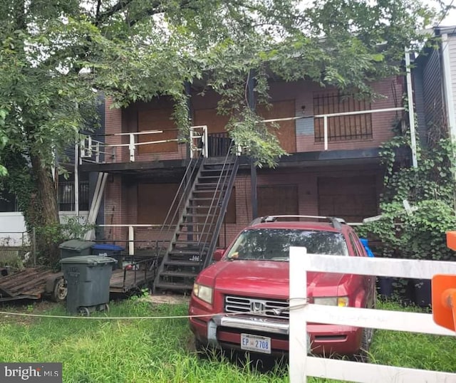 rear view of house with brick siding and stairway