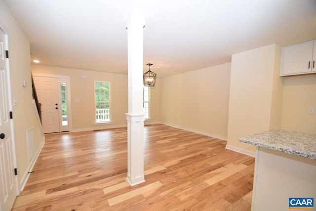 interior space with a notable chandelier and light hardwood / wood-style floors